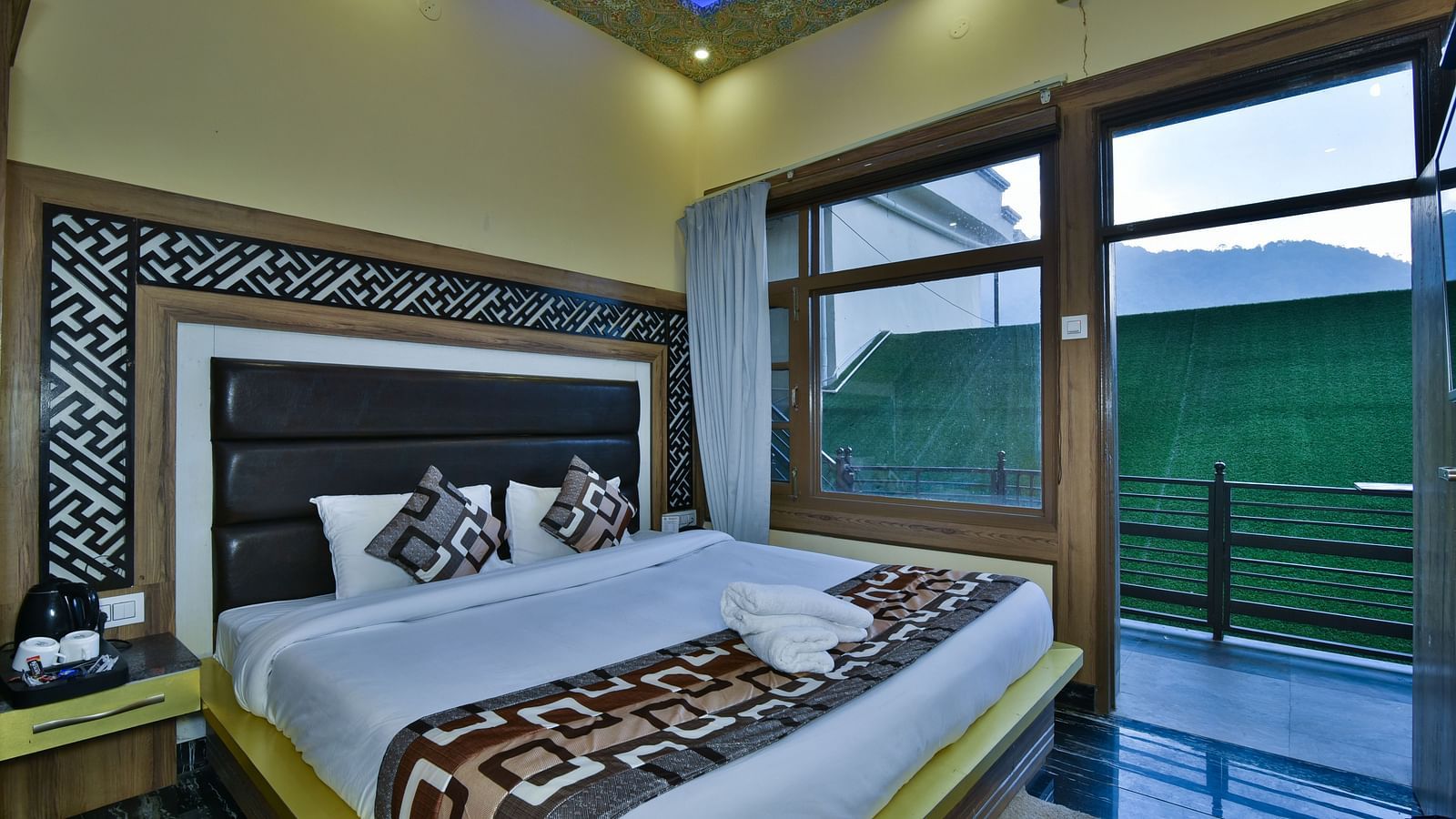 A Deluxe Room at DLS Dalhousie Valley Resort with a  king size bed and a balcony 